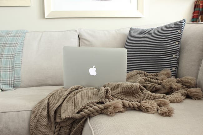 This corner of the couch looks cozy with blankets and throw pillows. 
