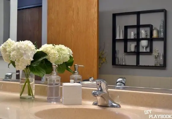 These bathroom accessories and fresh flowers are sophisticated and sleek. 