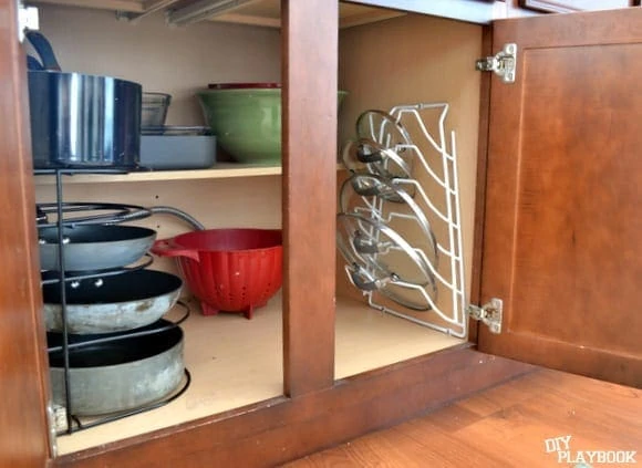 organized pots and pans in cabinet