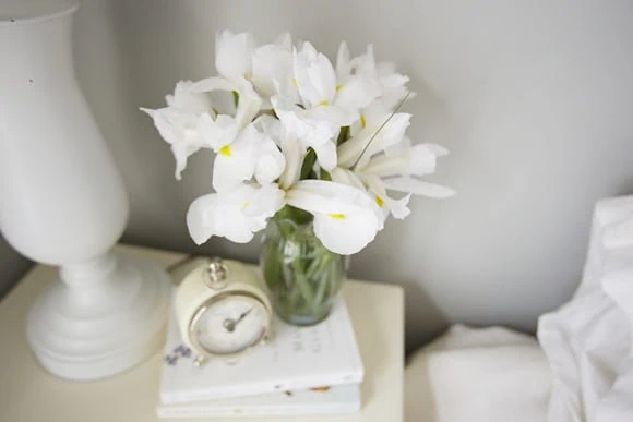 These fresh white flowers on the nightstand add a fun element to the room. 
