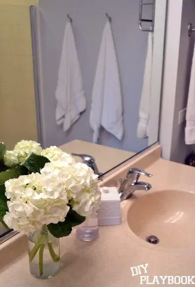 The white hydrangeas add a pop of freshness to the bathroom's decor. 