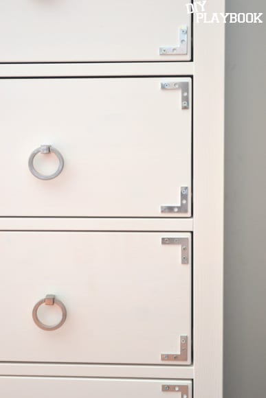 I used silver brackets to achieve an industrial, campaign-style look in the corner of each drawer to complete my IKEA Hemnes dresser hack.