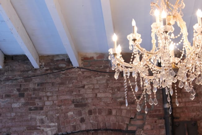 This classic chandelier looks beautiful against the brick wall.