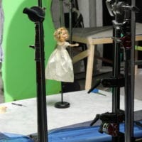 This creepy doll gets propped up in front of a green screen