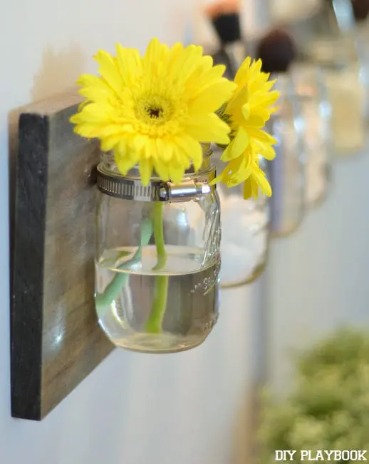 Yellow daisies in the mason jar brighten any bathroom space