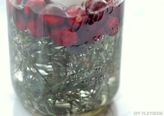 Small pieces of greenery should be placed at the bottom of the mason jar. 