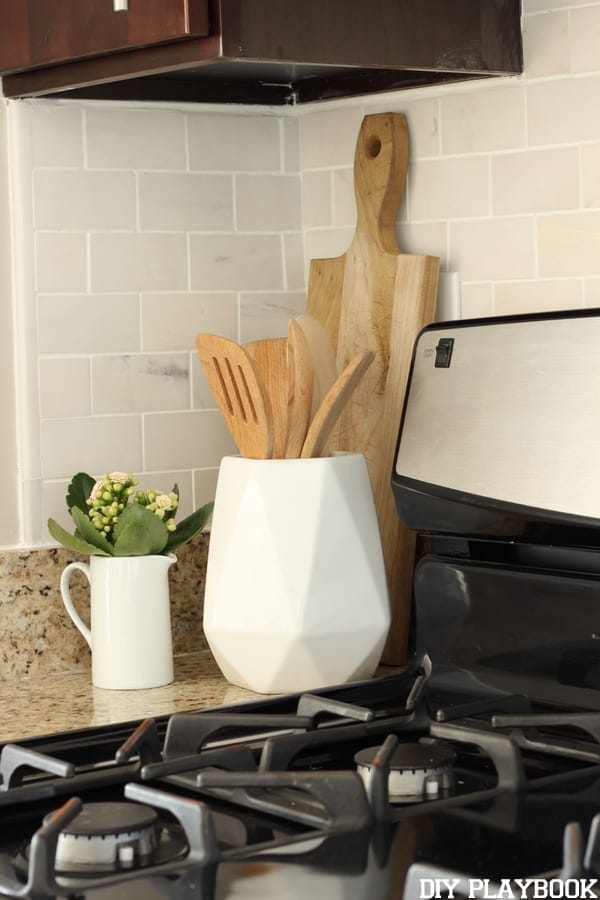 The backsplash looks great with wooden kitchen accessories. 