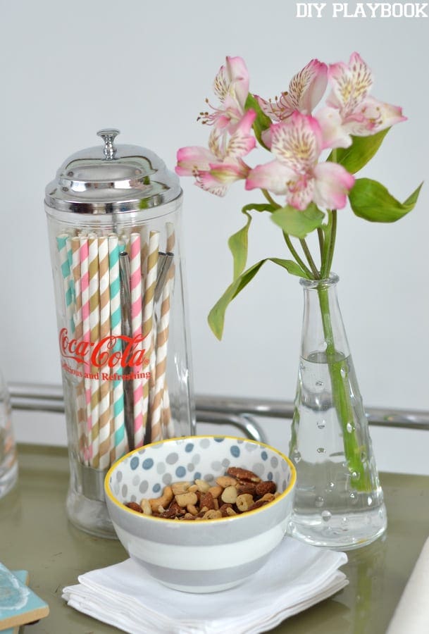 Straws, cocktail snacks and fresh flowers all make great bar cart accessories.