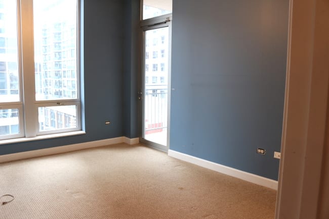 This bedroom has a lot of open space and clean carpet. 