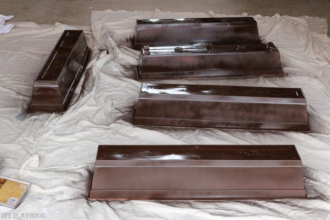Cover the plastic flower boxes with two coats of brown spray paint. 