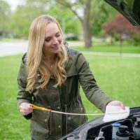 Casey checks her car's oil.