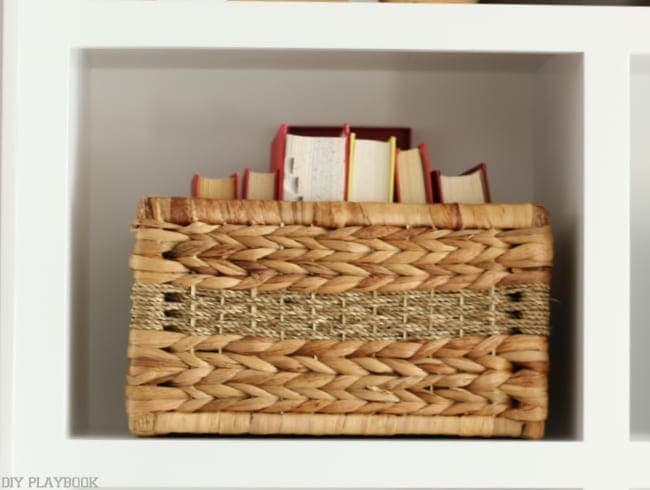 Wicker basket with books placed on the built-in bookshelf.