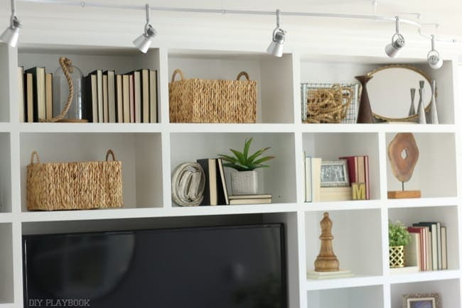 Built-in bookshelves with decorations and lighting. 