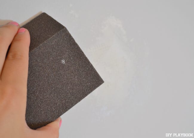 How to fix a hole in your wall: Sand down the excess spackle | DIY Playbook