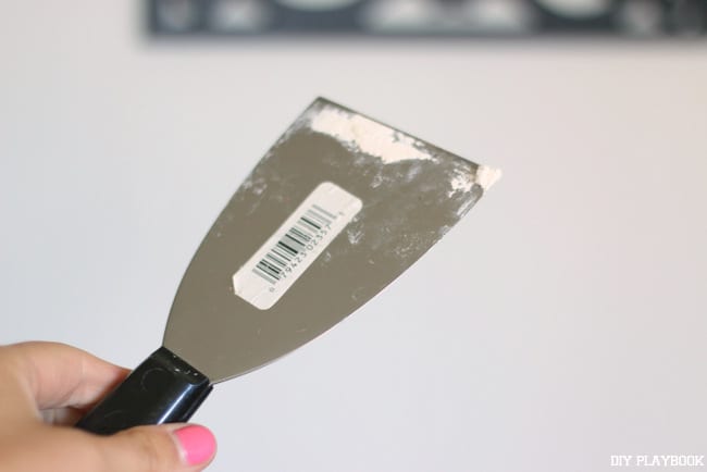 how to fix nail holes in the wall: get some spackle on a spackling spatula and get ready to spackle!