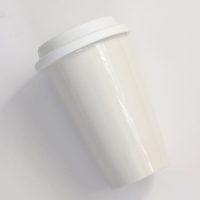 Plain white ceramic travel coffee mug.