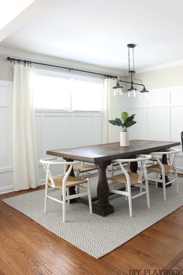 Dining room with light walls, board and batten and cream curtains. 