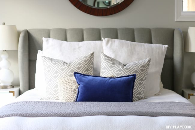 Master bedroom with blue and grey throw pillows. 