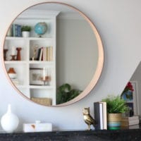 This circular mirror over the fireplace is a modern addition.
