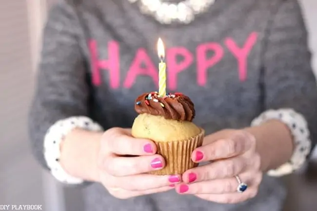 A cupcake with a lit candle for the DIY Playbook's birthday. 