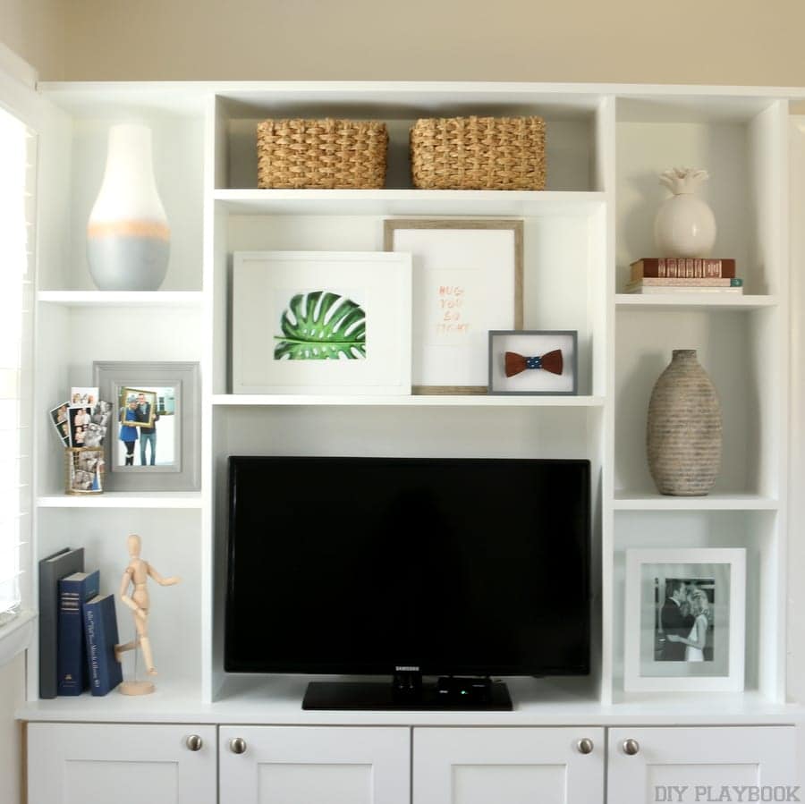 Entertainment center with gallery wall artwork and home accessories. 