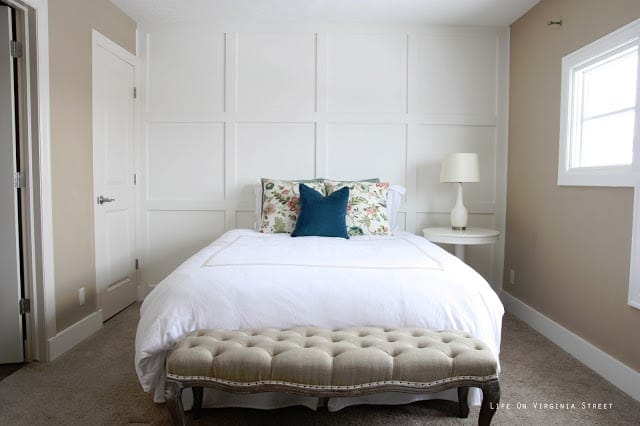 This simple white wood wall adds texture to a neutral guest room, 