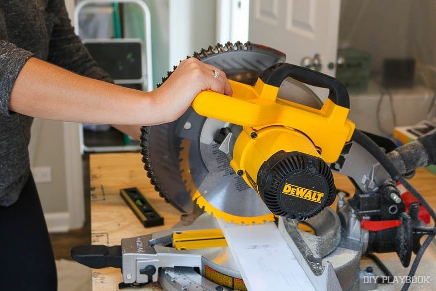 Using a DeWalt miter saw to cut wood for the guest room project. 
