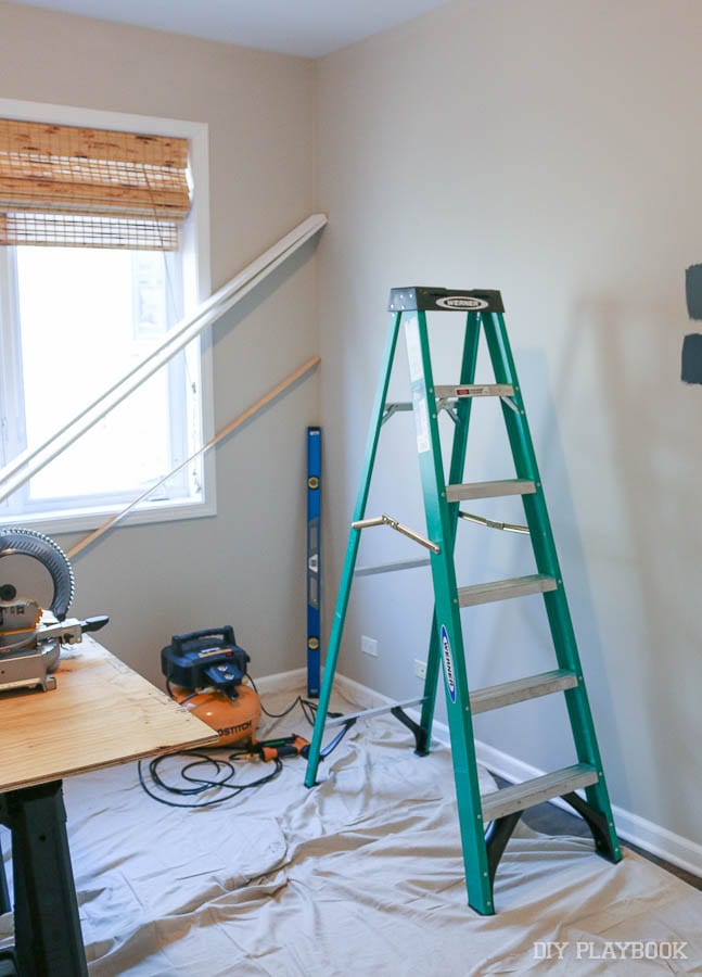 The DIY guestroom project with a ladder and supplies. 