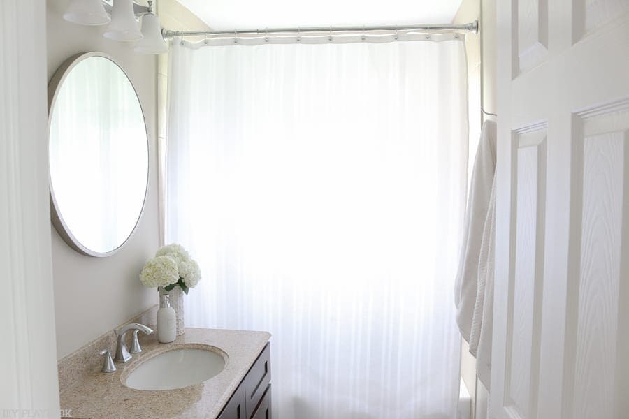 A bathroom with a new round mirror 
