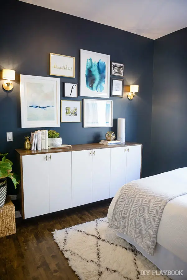 The pops of white in this bedroom pair well with the navy blue walls. 