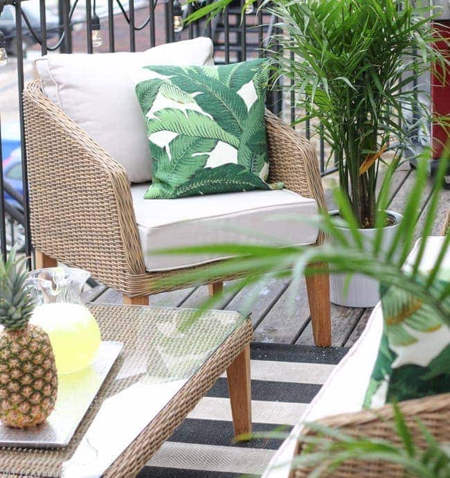 The modern wicker furniture is perfect for our balcony setting. I love the greenery and the banana leaf throw pillow!