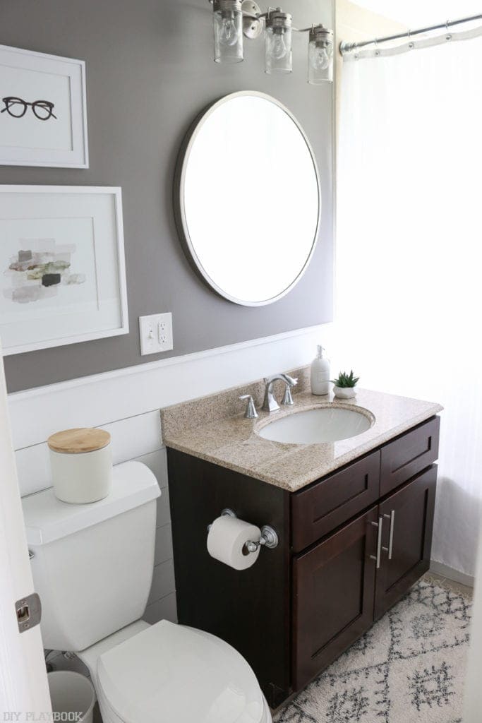 bathroom vanity mirror, sink, and hanging framed artwork. 