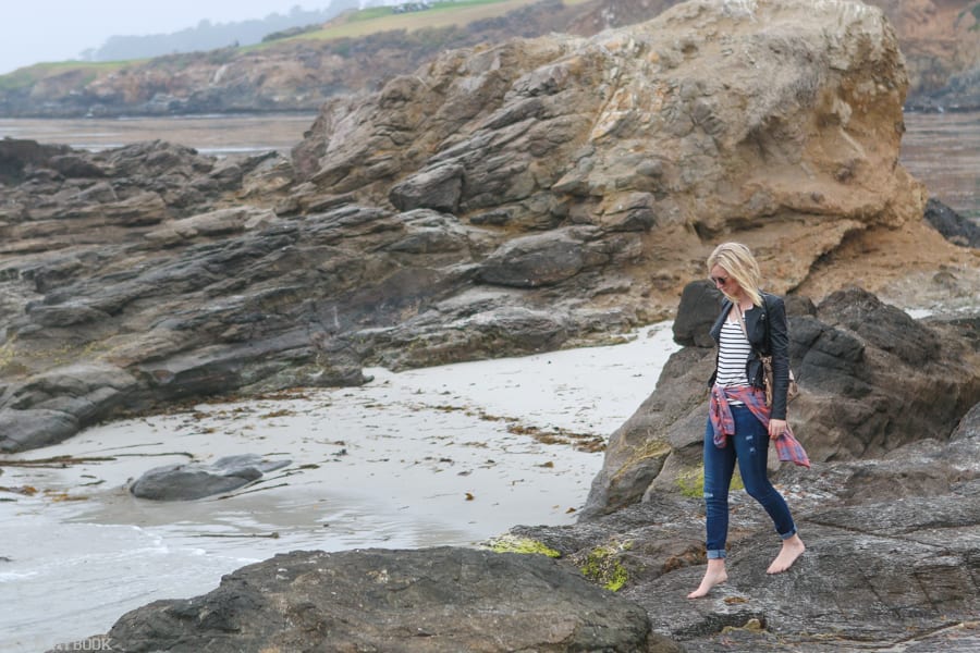 Bridget takes a careful walk along shoreline rocks on the beach off Highway 101. This was one of our favorite parts of our Seattle to San Francisco road trip!