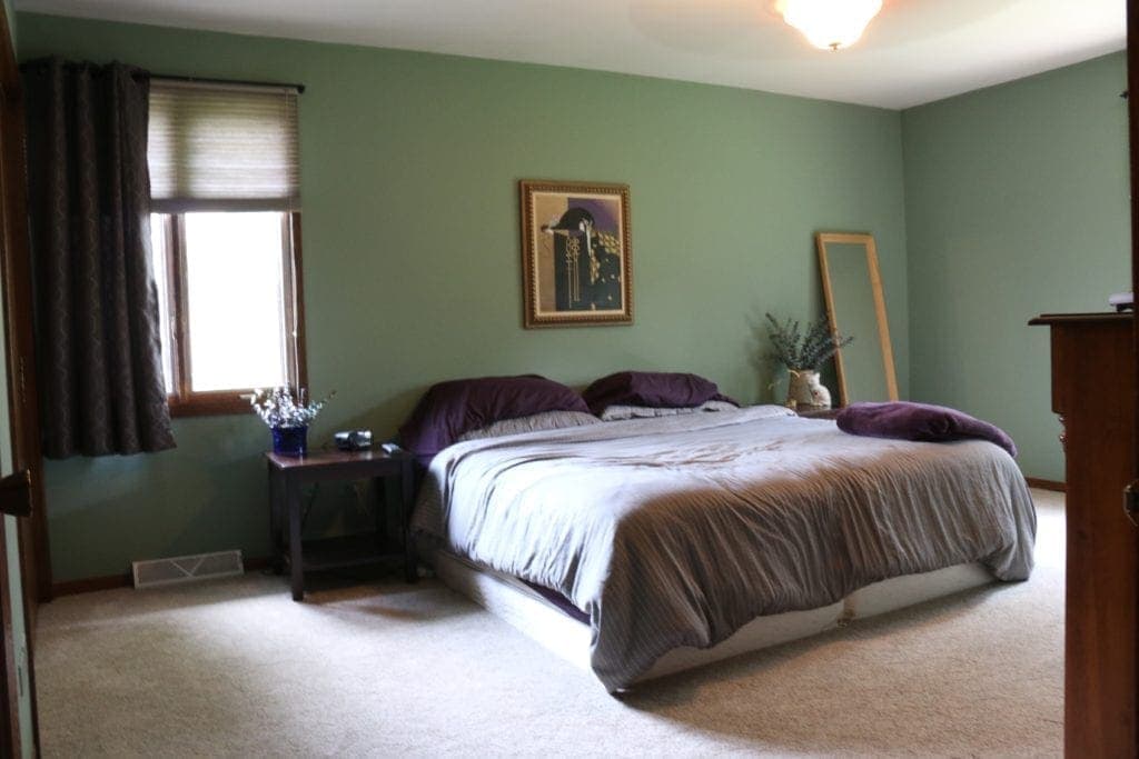 A green bedroom with wood trim
