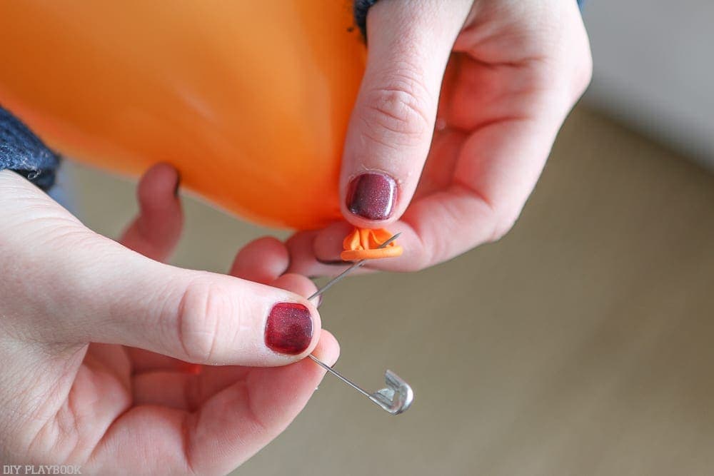 Carefully safety pin the end of the balloon