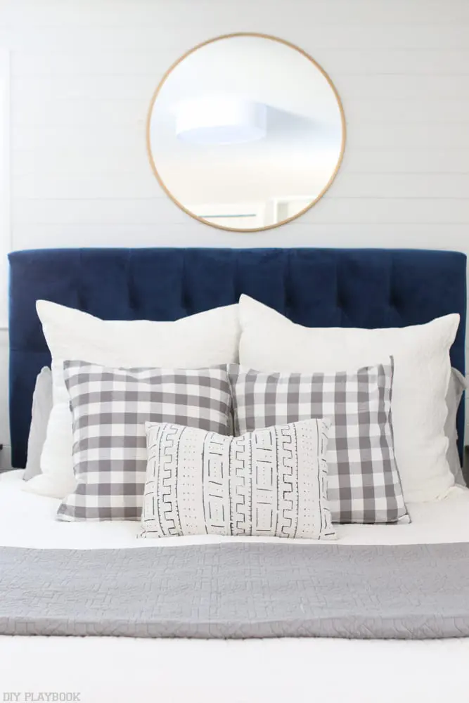 bedroom-navyheadboard-roundmirror-pillows