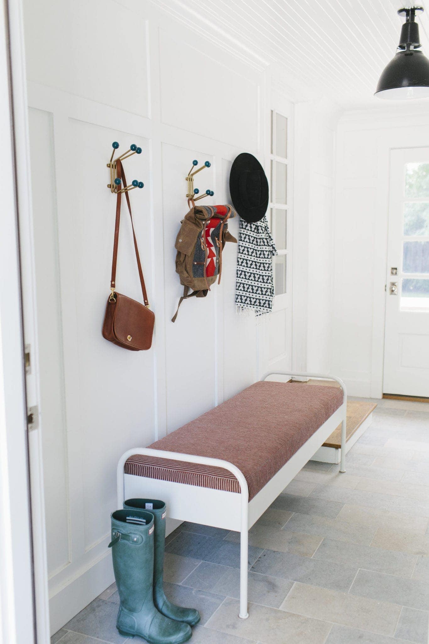 This striped bench near the entryway makes for a great mud room. 