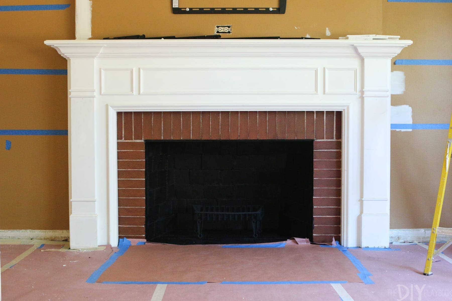 spray painting the inside of a white fireplace