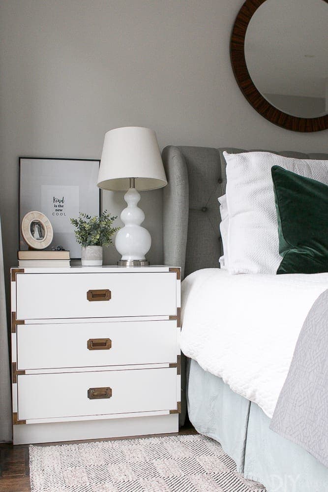 Master bedroom bedside table with lamp, accessories, and a small plant. 