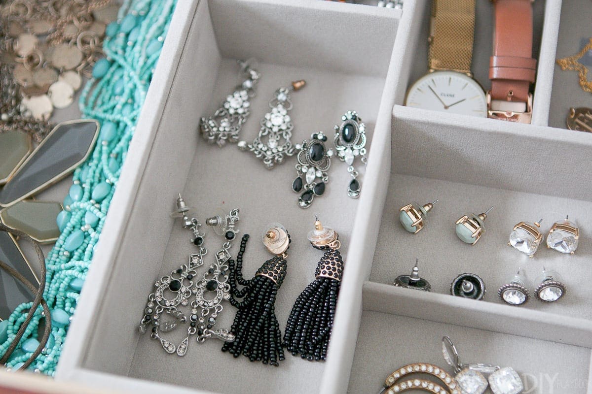 Using a jewelry drawer organizer to hold earrings in a dresser. 