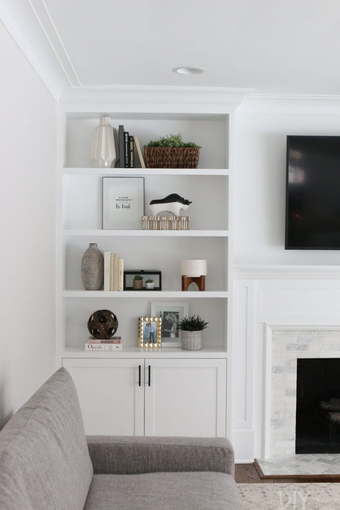 white family room built-ins hold home decor and accessories
