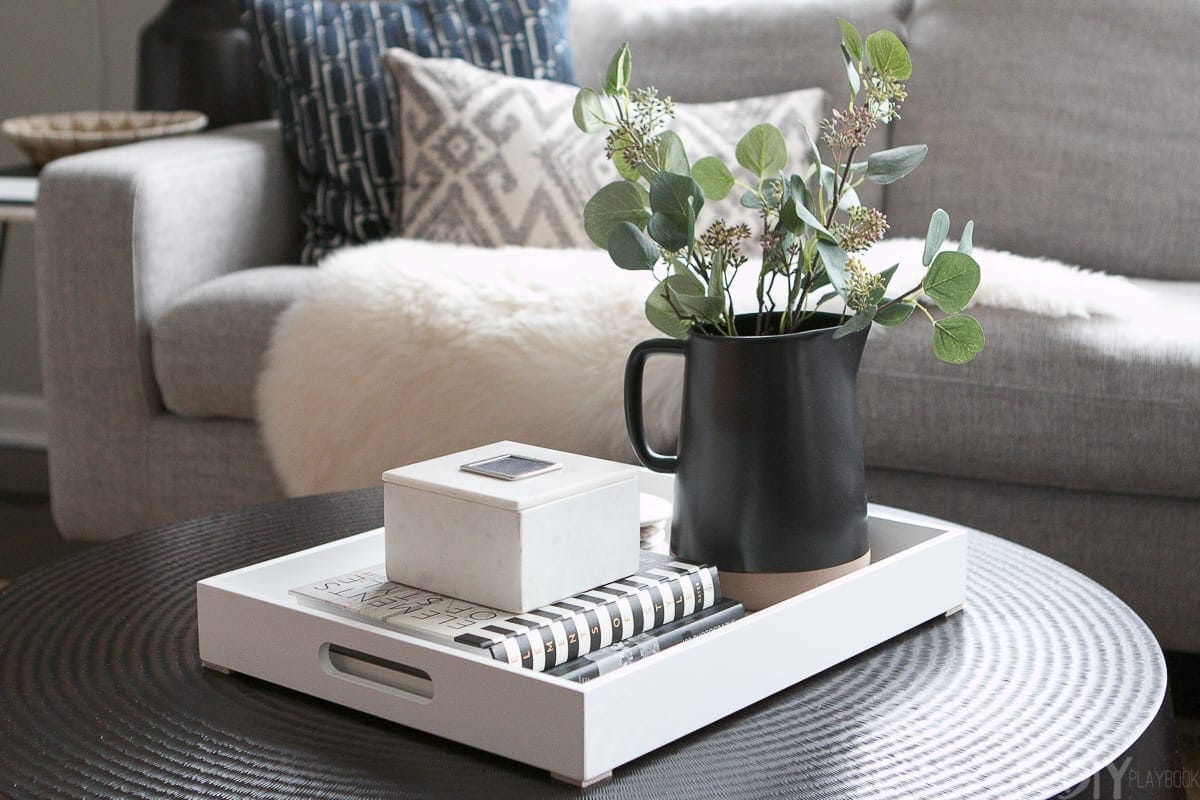 Put a rectangular tray on a round coffee table to balance all of the lines in the room. 