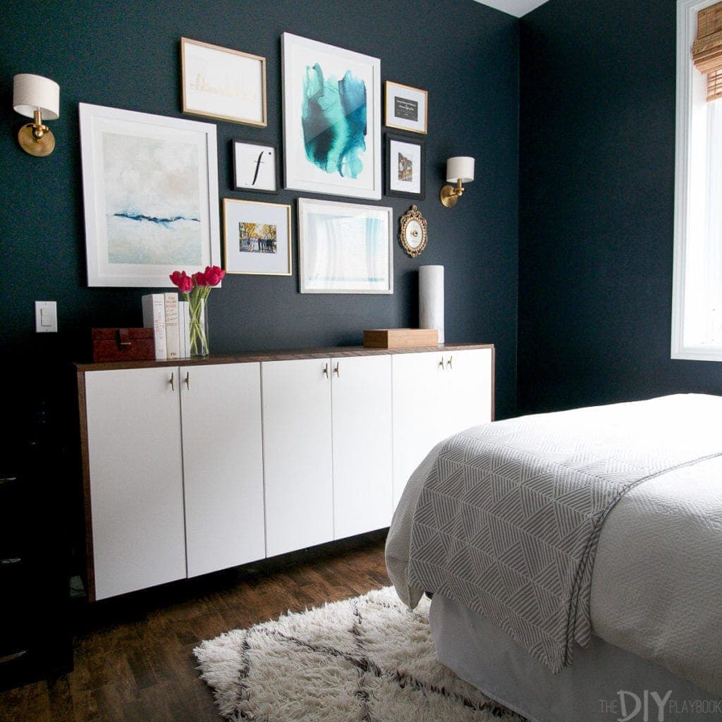 A navy guest room with a gallery wall