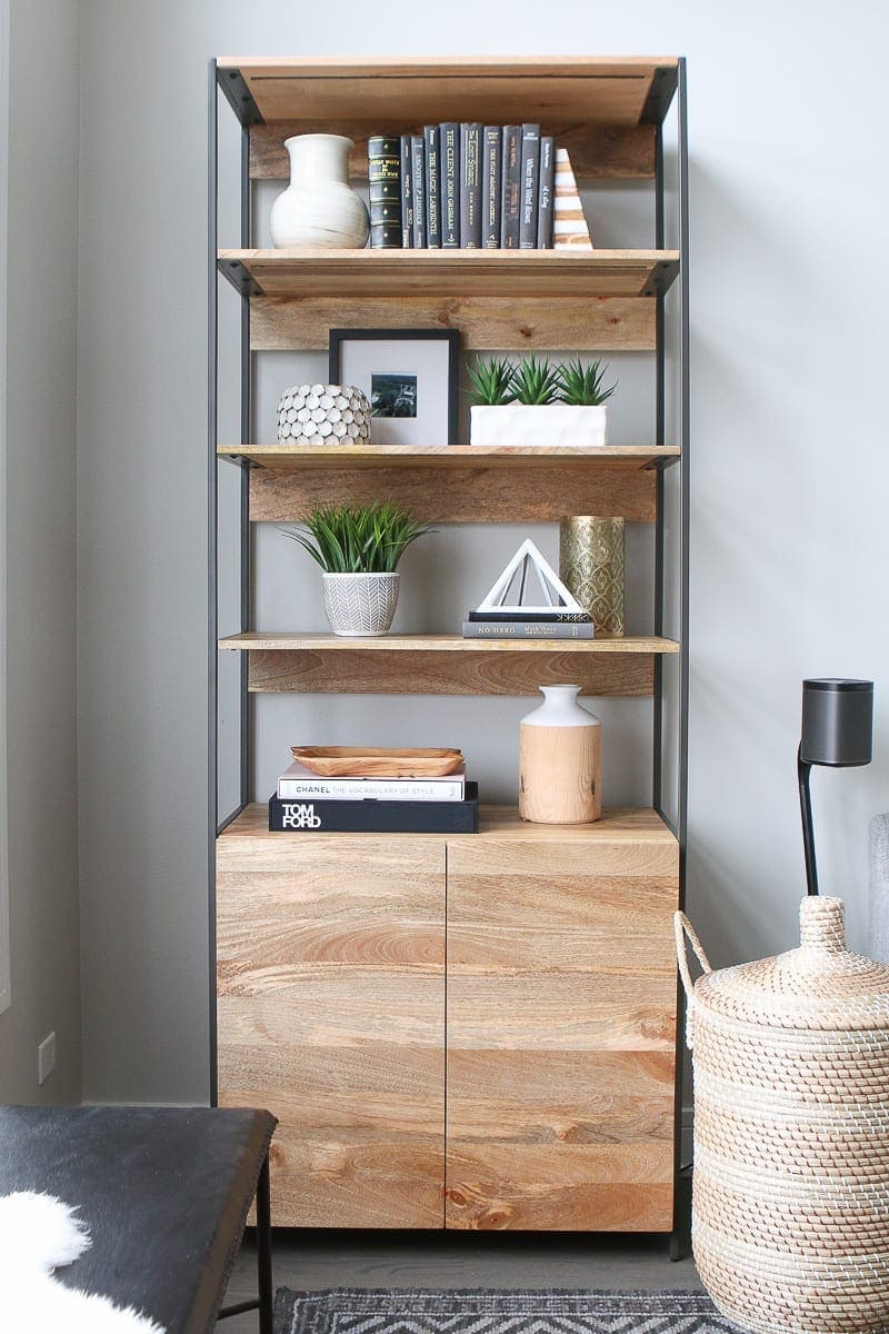 This bookshelf holds pretty items and accessories in this neutral living room space. 