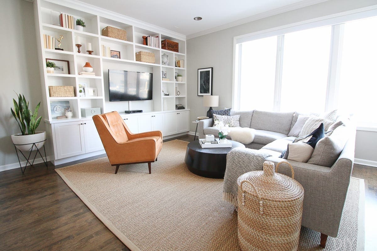 A family room space with white built-ins and a gray sectional 