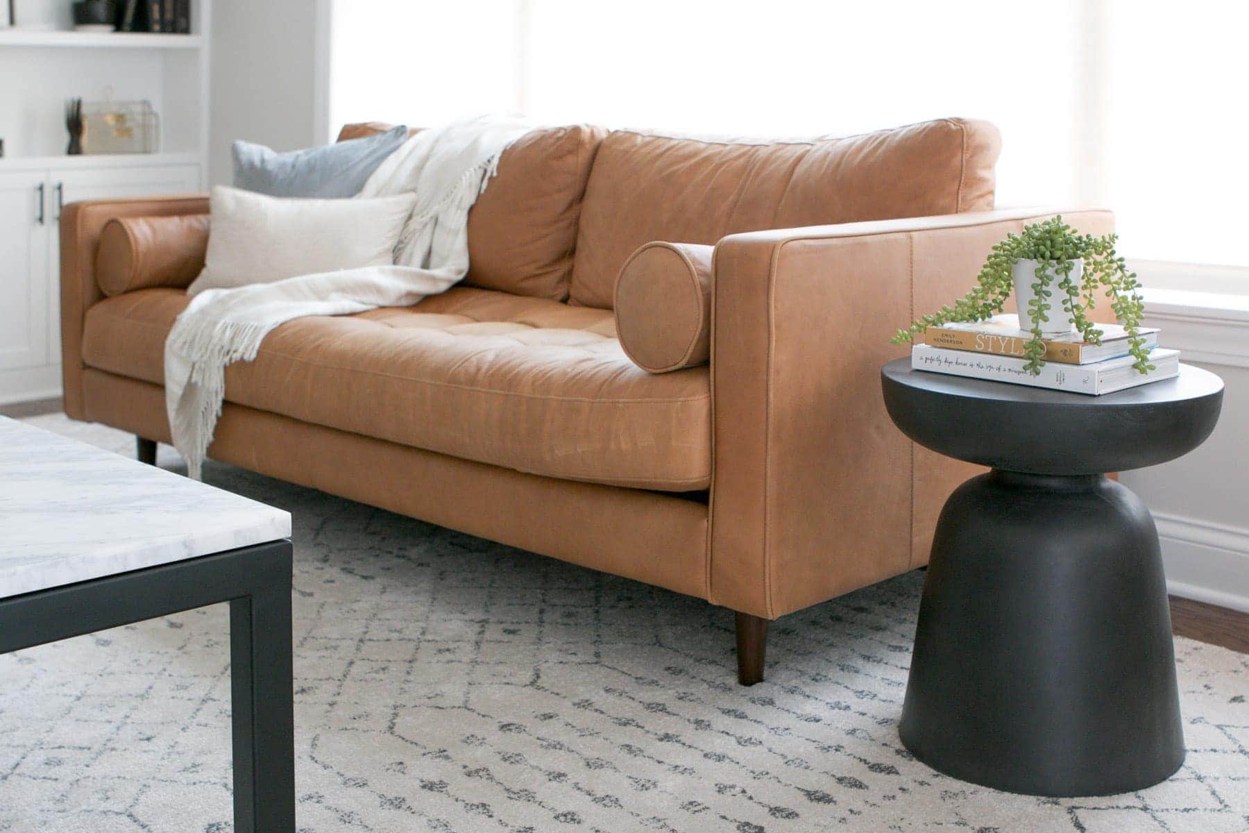 Adding a round black side table next to a couch is a good spot to rest a drink in your family room. 
