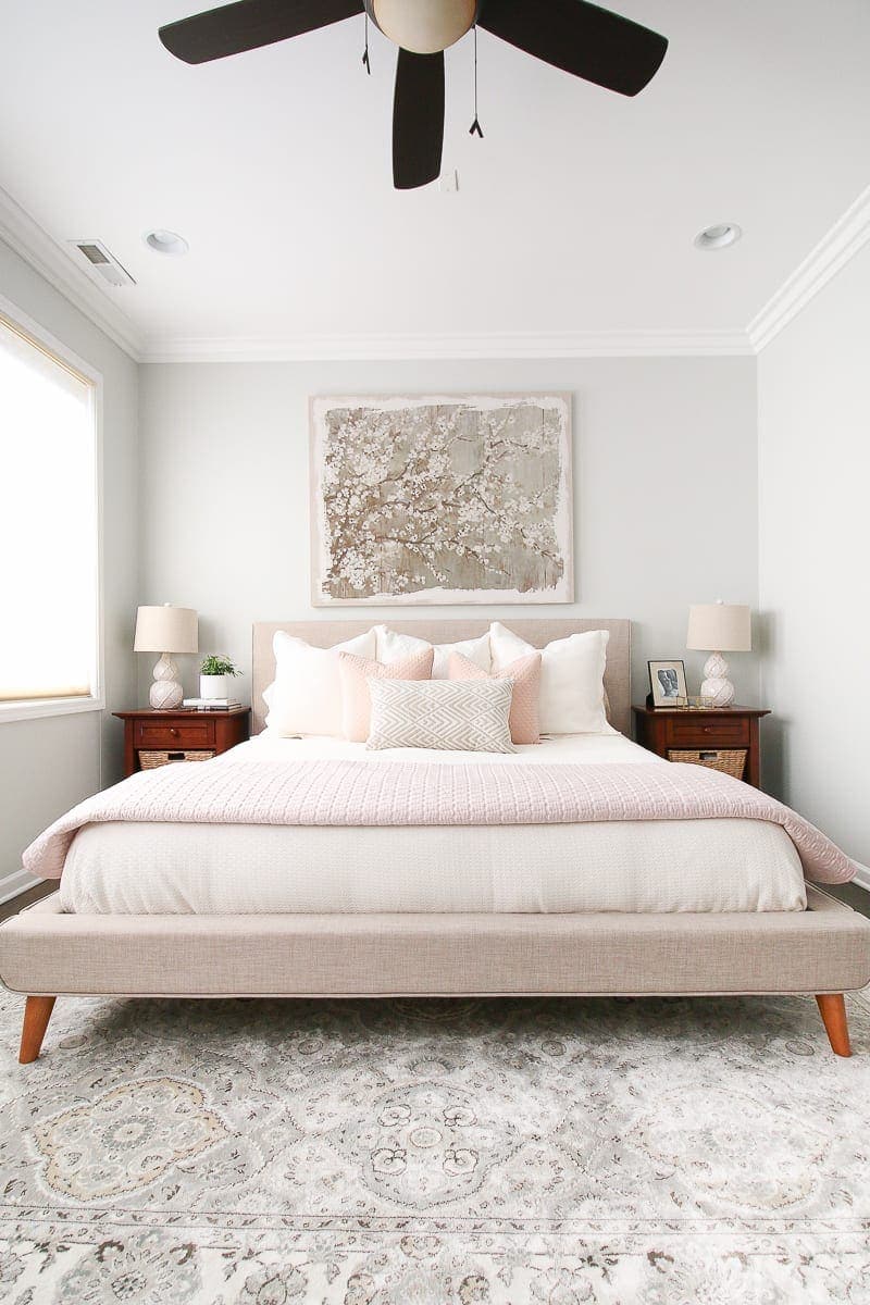 A neutral bedroom with blush accessories