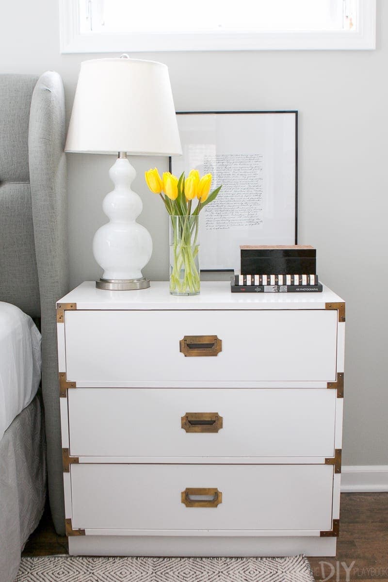 White campaign style nightstand with brass hardware