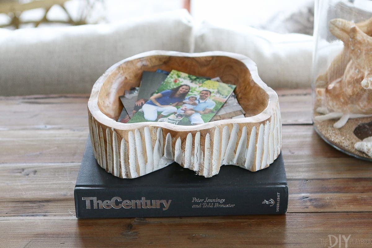A wooden bowl showcases loose pictures and polaroids and works as cute tabletop decor