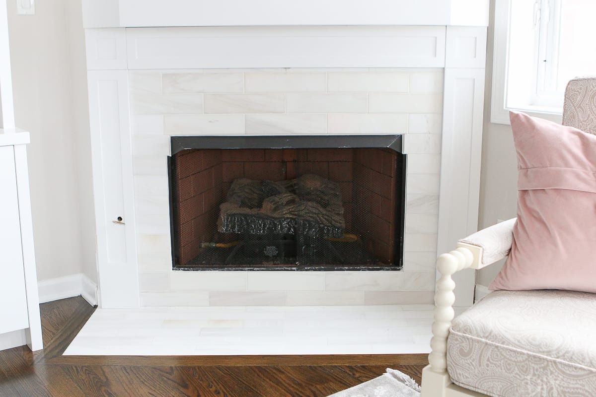 White marble subway tile around a fireplace
